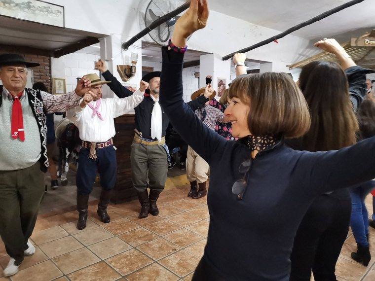 Carole dancing with a group in Argentina, arms raised