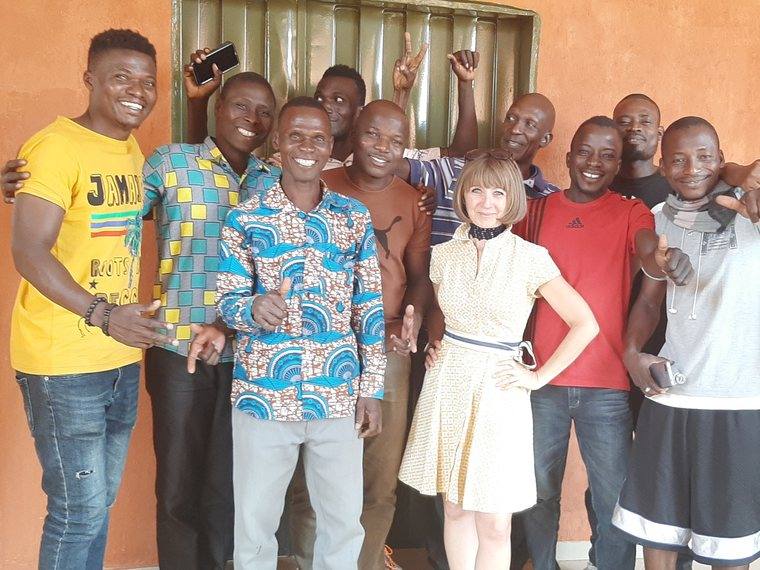 Carole with a group of men in Benin, all smiling for the camera